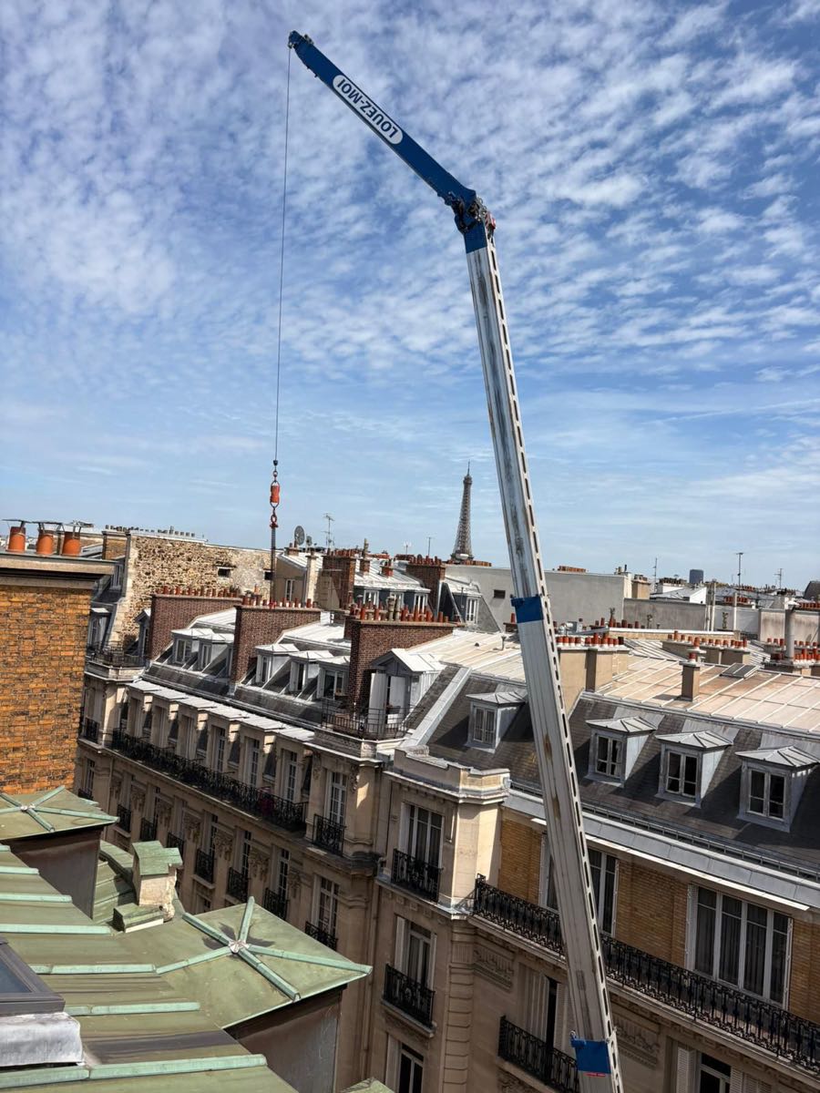 Flèche de la grue AÉRO LEVAGE déployée au-dessus des toits de Paris, Tour Eiffel en arrière-plan, 16e arrondissement